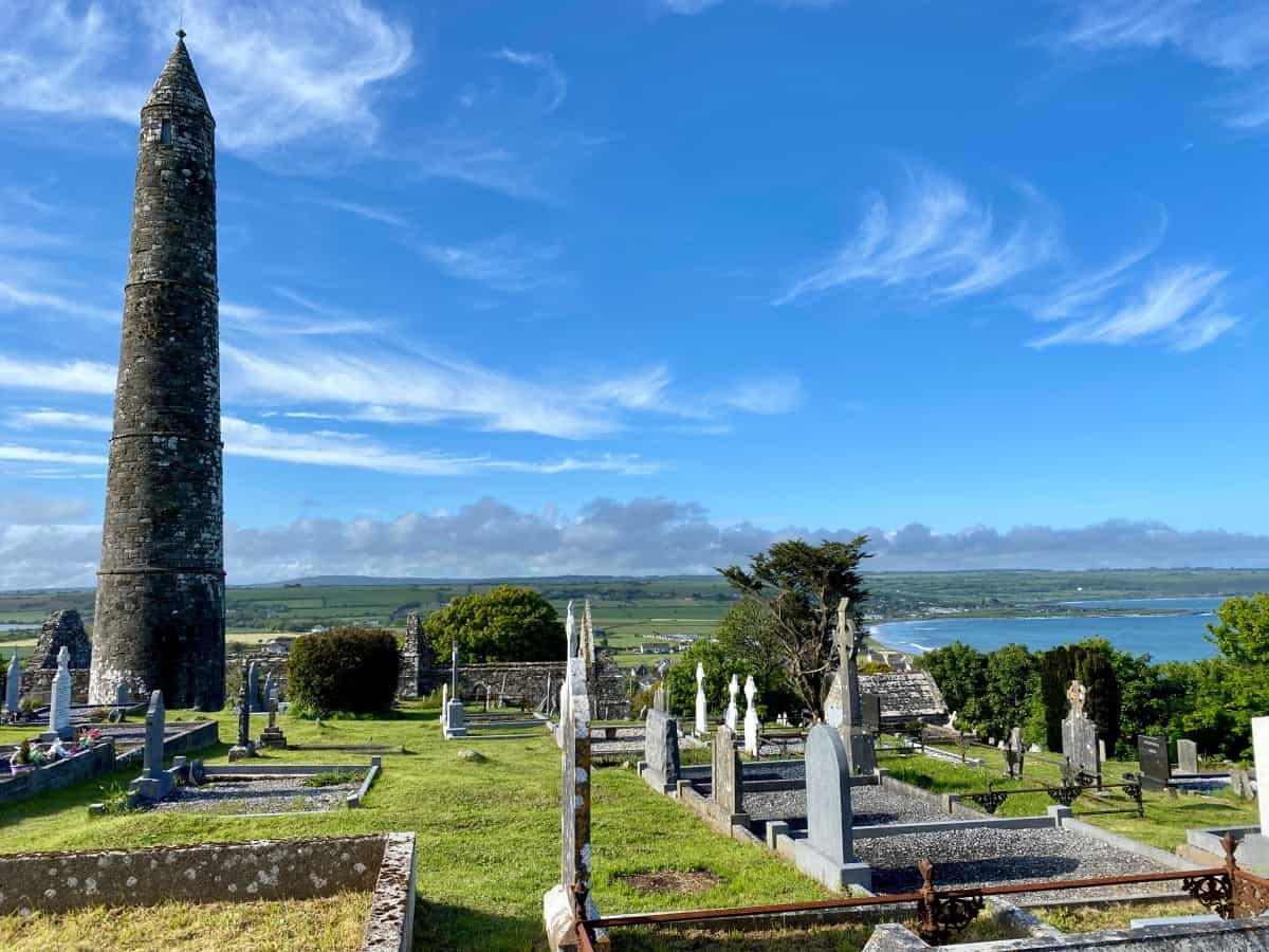 Cemetery with a tall stone tower against a blue sky