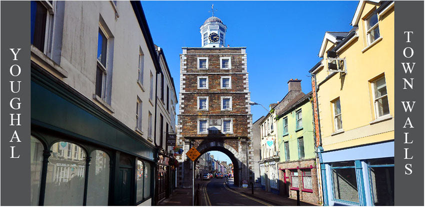 Town street with a clock tower in the center under a clear blue sky.